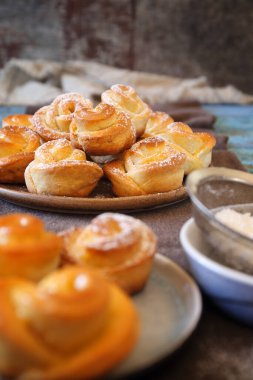 Ev yapımı gül çiçekli çörekler (kurabiye), pudra şekeri sosu, ahşap arka plan, seçici odak