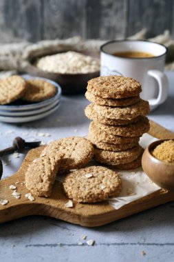 Rafine edilmemiş esmer şekerli gevrek yulaflı kurabiyeler ve kahve molası için bir fincan kahve. 