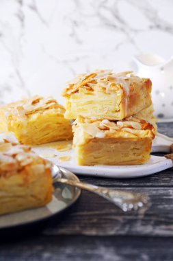 Fransız mutfağı. Görünmez elmalı tart, badem yaprakları ve beyaz krema sosu. 