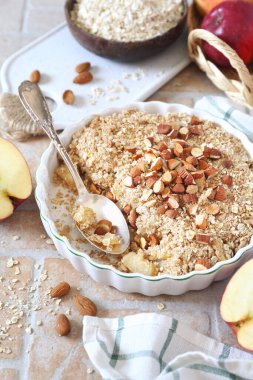Yulaf ezmesinden taze elma parçaları, arka planda badem sosu.