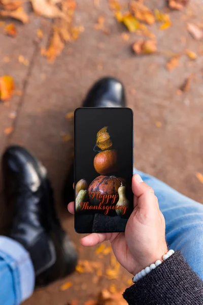 Mężczyzna Trzyma Smartfona Zdjęciem Happy Thanksgiving Ekranie Parku Pełnym Jesiennych — Zdjęcie stockowe