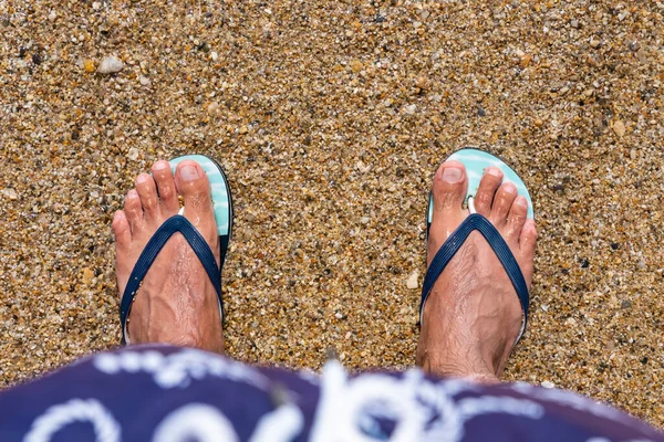 Mans feet in flip-flops at the beach. Top view. Flat lay. Copy space, Add text