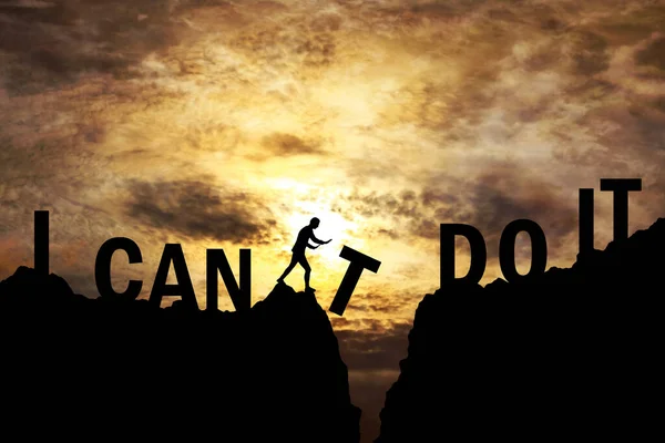 I can't do it, I can do it text on mountain top and man pushing letter T from the cliff silhouette with sunset sky in background. Business, success and idea concept illustration