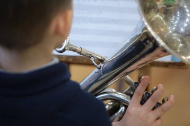 Çocuk müzik aleti çalıyor. Gümüş trompet arka plan müziği.