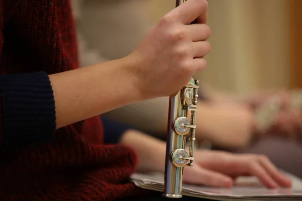 Fragment of a schoolgirl with a musical instrument flute and notes girl\'s hand close-up of a student in a music lesson listening to a lecture background image