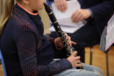 Klarnet çalan kız öğrenci notalar üzerinde müzik aleti yakın plan bulanık arka plan öğretmeninde