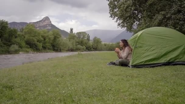 Kvinna camping i ett mysigt tält, titta på det fantastiska landskapet, utomhus äventyr livsstil. — Stockvideo