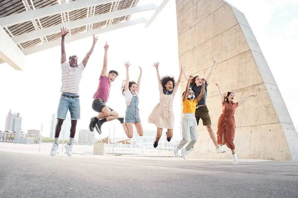 Μια ομάδα από χαρούμενους πολυεθνικούς φίλους που διασκεδάζουν. Νέοι φοιτητές που πηδούν έξω από το πανεπιστήμιο. — Φωτογραφία Αρχείου