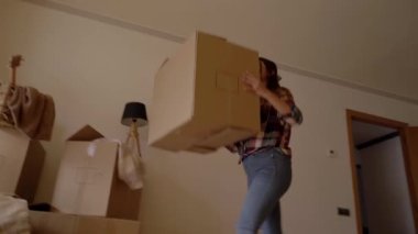 Hareket ettikleri için birbirlerine karton kutular atan iki kadının yakın plan portresi. Yeni bir ev taşınmasında yeni bir hayat.