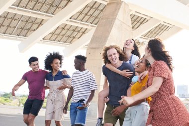 Arkadaş canlısı çok ırklı arkadaşlar eğleniyor. Üniversite ya da şehir dışında sarılan genç öğrenciler.