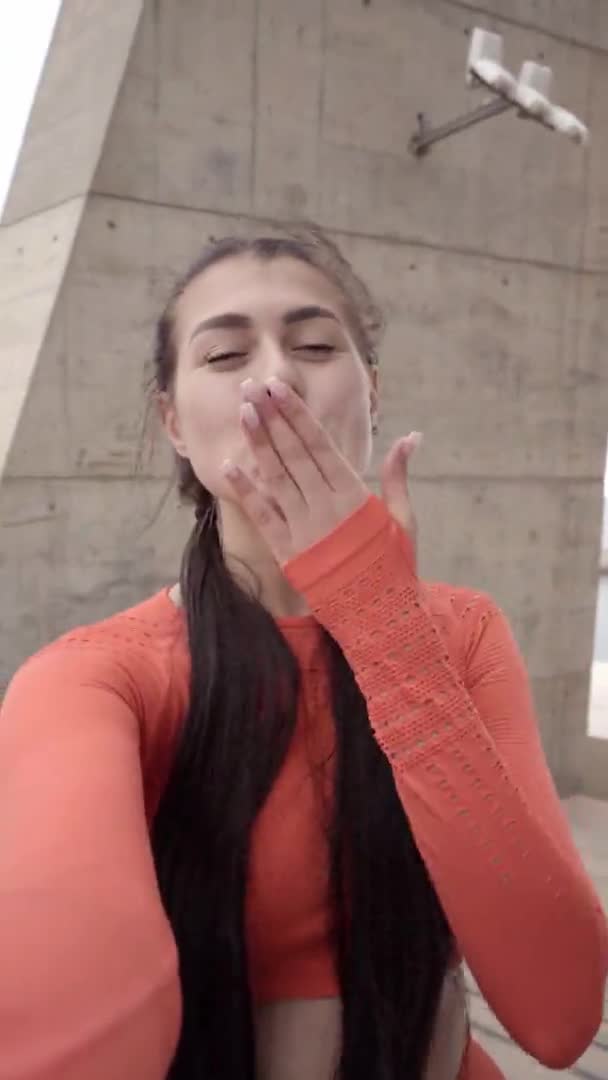 Widok kamery uśmiechnięta młoda kobieta sportowiec na ulicy miasta i rozmowy z przyjacielem za pośrednictwem połączenia wideo, zdrowego stylu życia i nowoczesnej koncepcji technologii. — Wideo stockowe