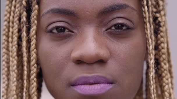 Nahaufnahme eines Porträts einer jungen Afrikanerin, die ernst in die Kamera blickt. — Stockvideo