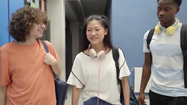 Multi-etnische klasgenoten lopen door de gangen van de middelbare school terwijl ze met elkaar praten. Vrienden die samen delen. Terug naar school. — Stockvideo
