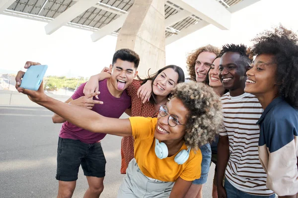 Bir grup farklı arkadaş eğleniyor. Cep telefonuyla selfie çekiyorlar. Dostluk ve teknoloji kavramı.