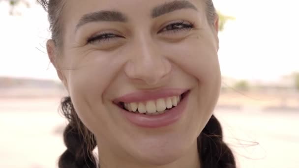 Close up de bela mulher caucasiana olhando para câmera sorridente. Menina beleza feminina rindo feliz e orgulhoso ao ar livre. — Vídeo de Stock