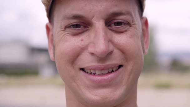 Detailní záběr portrétu usmívajícího se mladého bělocha dívajícího se do kamery. — Stock video