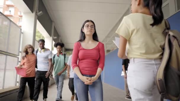 学校の廊下に立っているオタクの10代の女の子は男の子が続くと笑っています。美しいいじめ白人高校生と公立学校でいじめの肖像画。行動概念. — ストック動画