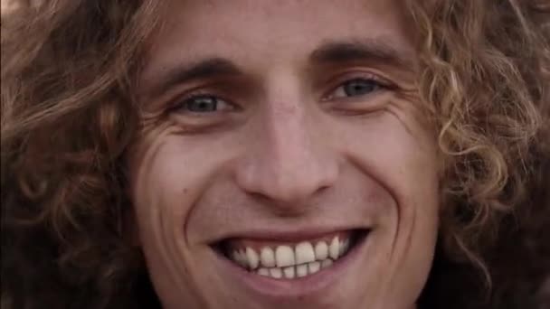 Potret pria muda Kaukasia yang ramah dengan rambut keriting di kamera tersenyum. Konsep orang-orang positif. — Stok Video
