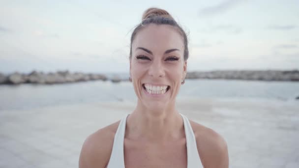 Smiling woman in sportswear happily looking at camera outdoors. — Stock Video