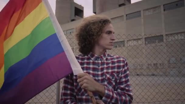Mladý aktivista drží vlajku homosexuální hrdosti. Demonstrace na podporu homosexuální komunity. — Stock video