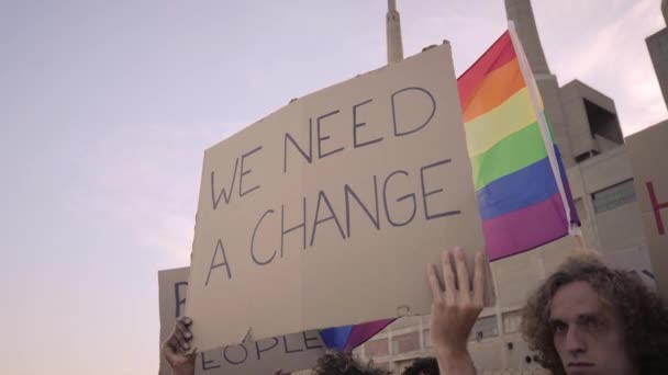 一个举着横幅的人在同志骄傲活动上说：我们需要改变. — 图库视频影像