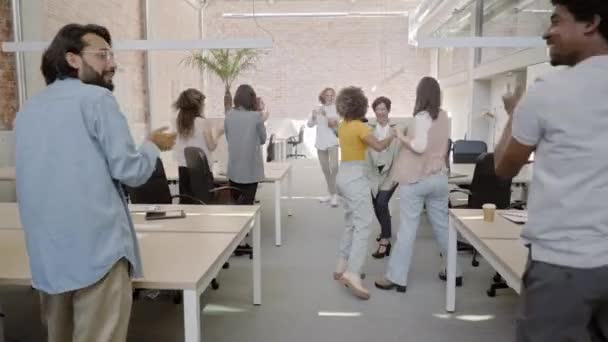 Business team geniet van succes in modern kantoor. Multiraciale gelukkige collega 's vieren goed nieuws, bewegen, glimlachen, handen omhoog. Concept van mensen, overwinning, werk. — Stockvideo