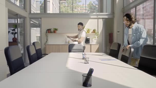 De kantoorvergadering begint en de werknemers gaan zitten. Creatief business team in modern start-up kantoor. — Stockvideo