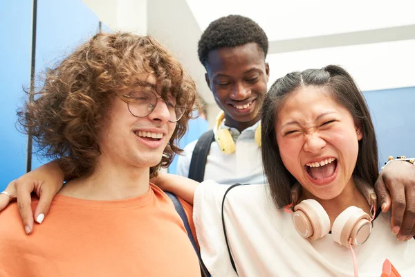 Πορτρέτο τριών πολυφυλετικών μαθητών που κοιτούν την κάμερα χαμογελώντας σε ένα γυμνάσιο. — Φωτογραφία Αρχείου
