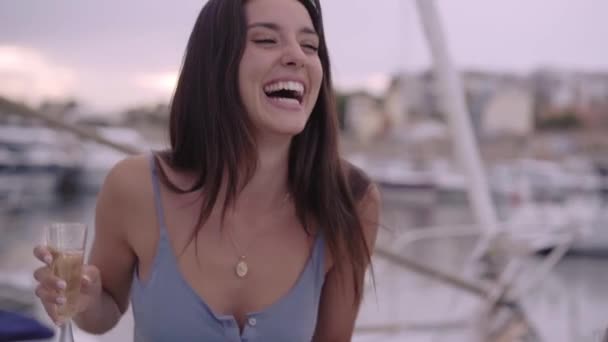 Schönes Lächeln einer jungen Frau, die auf der Party im Yachthafen am Meer tanzt. — Stockvideo