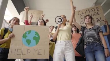 Çevre ve koruma sloganları taşıyan çok ırklı bir grup genç protesto yürüyüşü yapıyor. Öğrencilerin Ekoloji Bilinci Protesto Ediyor.