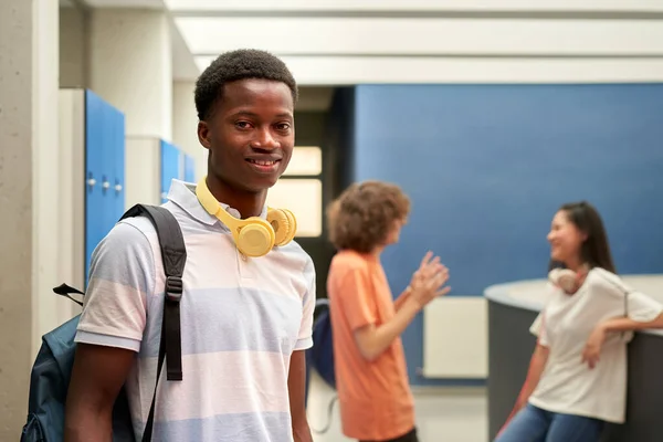 Portrait of an African American student looking at the camera in the school hallway. — Zdjęcie stockowe