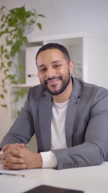 Webcam view of a video conference of a smiling happy. businessman looking at the camera and listening. Formal videoconference at a business meeting.