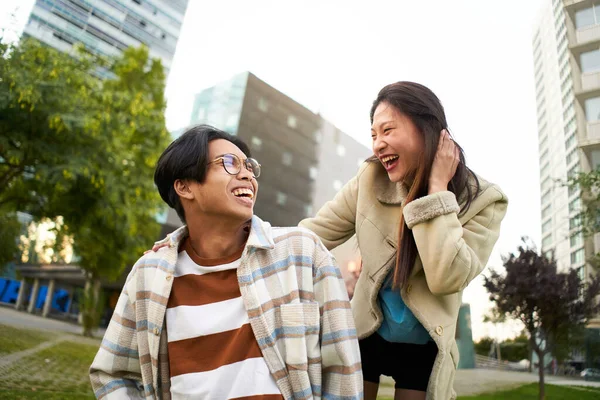 Glücklich lächelndes asiatisches Paar, das Spaß hat und sich gegenseitig ansieht. Junge Liebende machen Urlaub. Jugendkultur und städtischer Lebensstil. — Stockfoto