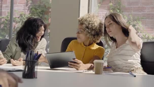 Diversi gruppi di colleghi che lavorano insieme e guardano alcuni divertenti in un tablet in ufficio. — Video Stock