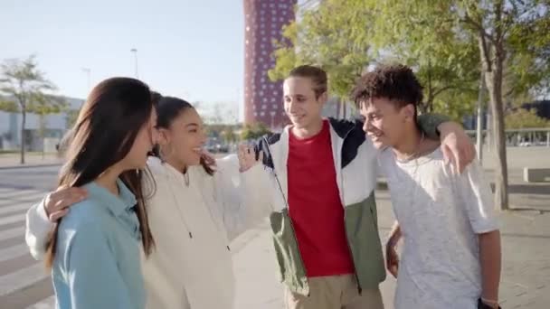 Fiatalok csoportja, akik jól érzik magukat együtt, és egymásra rakják a kezüket a szabadban. A városon nevető többnemzetiségű diákok portréja. — Stock videók