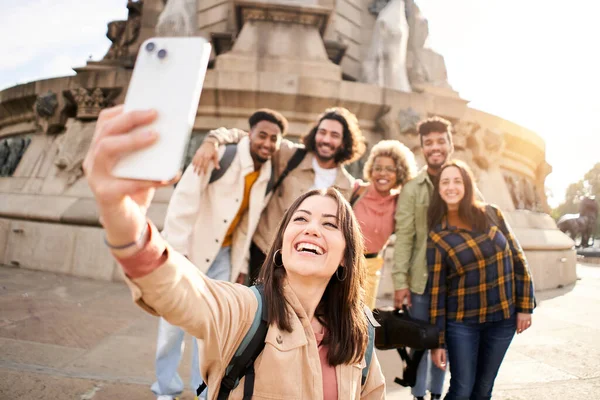 Grupa wieloetnicznych młodych ludzi robi szczęśliwe selfie z uśmiechem. Studenci bawią się na świeżym powietrzu. Piękna kobieta zrobić zdjęcie w smartfonie z przyjaciółmi. — Zdjęcie stockowe