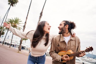 Mutlu çift şehirde gitar çalarak şarkı söylüyor ve dans ediyor..