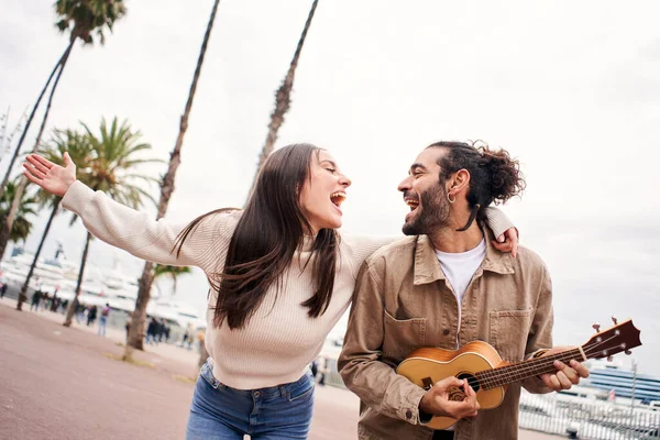 Mutlu çift şehirde gitar çalarak şarkı söylüyor ve dans ediyor..
