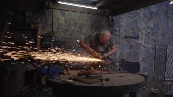 Vecchio negozio di fabbri con stile cinematografico. Lavoratore tagliare un ferro con una sega radiale mentre scintille volare come l'artigiano taglia ferro sul banco da lavoro. — Video Stock