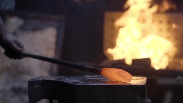 Movimiento lento de las manos de herreros con martillo golpeado en el metal caliente incandescente, en el yunque, el proceso de forja. — Vídeo de stock