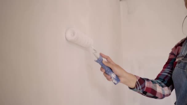 Rullmålning vit vägg med färg. Hand av en arbetare som renoverar rummet med ljus färg. Närbild. Övergångskoncept. — Stockvideo