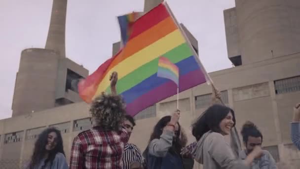 시위대는 거리 열병식에서 무지개 색깔의 깃발을 흔들었다. 뉴욕에서 게이 프라이드 행진에 참가하는 사람들. — 비디오