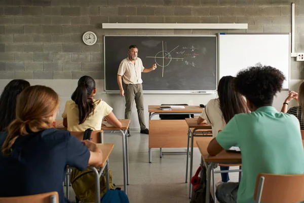 Öğretmenler okulda öğrencilere ders verir. Lisede eğitim..