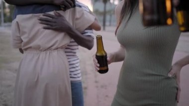 Kutlama bira konsepti, açık hava partisi tatilinde bira şişelerini tutan insanlar. Kapatın. Yavaş çekim