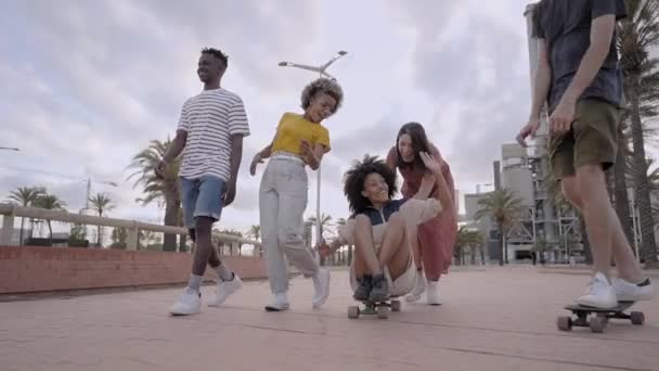 Bir grup genç şehirde kaykay yaparken eğleniyor. Milenyum arkadaşları birlikte olmayı kutluyorlar. Çok ırklı insanlar.. — Stok video