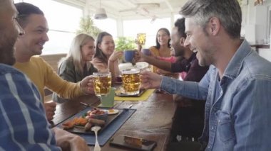 Çok kültürlü insanların kahvaltlarını ve tezahüratlarını yakından izliyorlar. Teras barında mutlu topluluk eğlencesi. Yavaş çekim