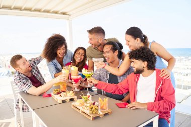 Çok Irklı Gençler Arkadaşları birlikte eğleniyor çatıda kokteyl içiyorlar. Sosyal toplum yaşam tarzı kavramı
