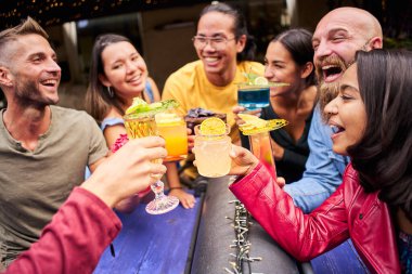 Dostlar kadeh kaldırıyor ve tropikal meyve margaritası tutarak şerefe diliyor. Karpuz ve tutkulu meyve içecekleri. Cama odaklan.