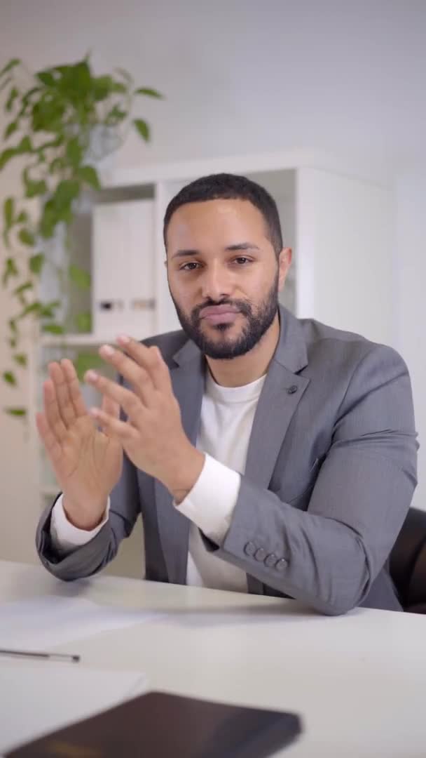 Vídeo vertical. Webcam vista de una videoconferencia de un feliz hombre de negocios afroamericano, aplaude y felicita celebrando éxitos. — Vídeos de Stock