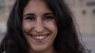 Gülümseyen kameraya bakan İspanyol bir kadının açık hava portresi. Mutlu bir yüze yakın çekim. İnsanlar ve duygular kavramı.